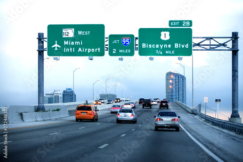 Cars moving on a highway with directional signs to Miami International airport