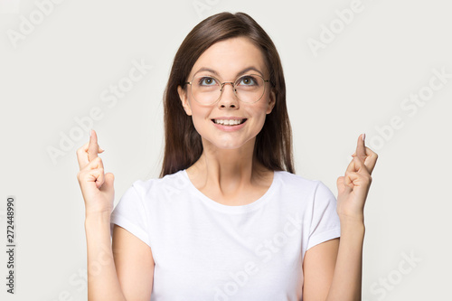 Comical woman in glasses crossing fingers asks for good luck