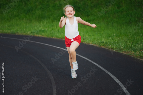 happy little girl running on the stadium