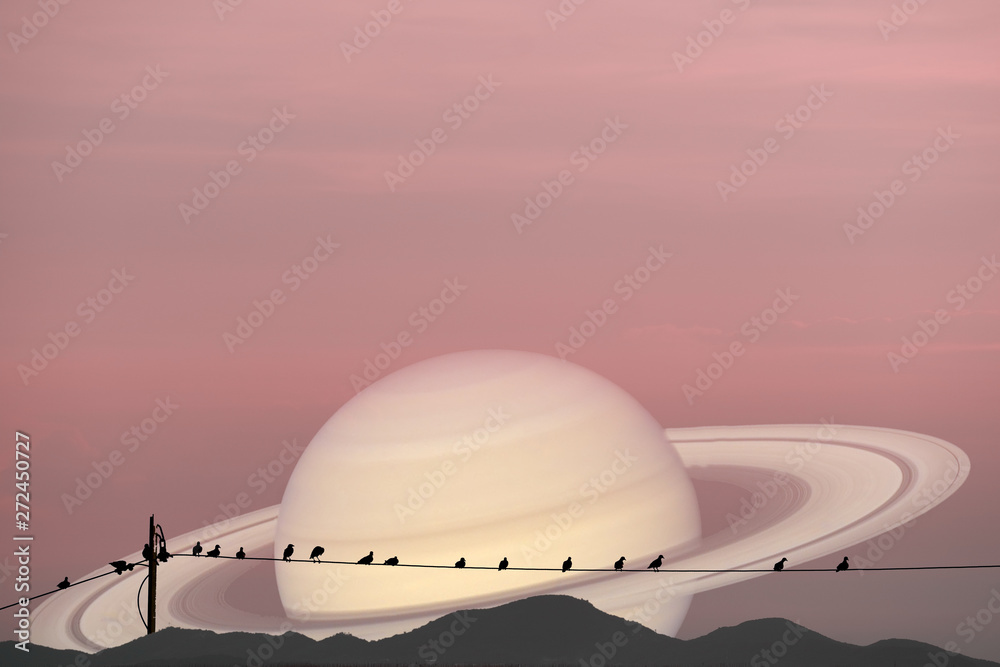 Saturn planet back silhouette birds on power electric line and mountain background