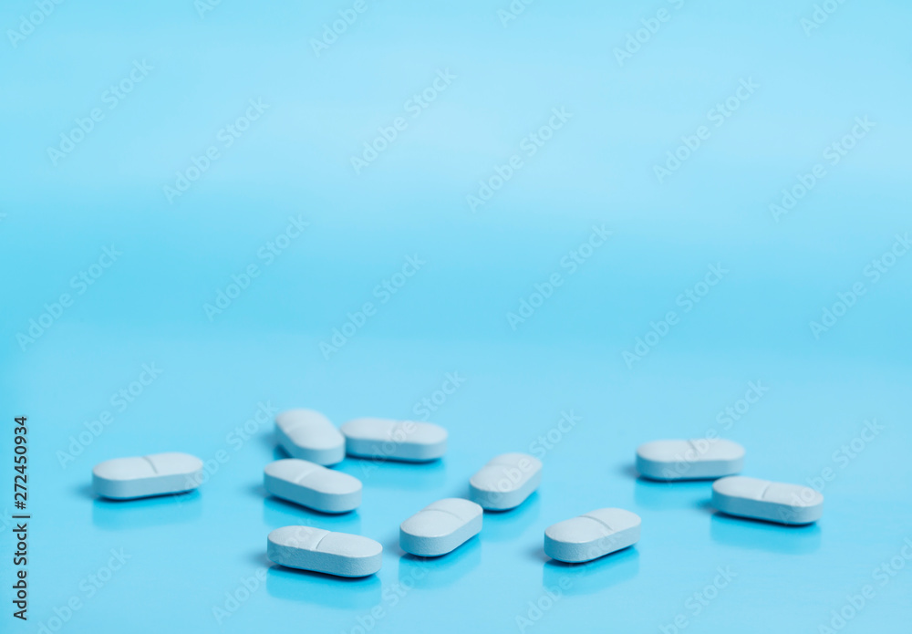 Blue medical pills on a blue background