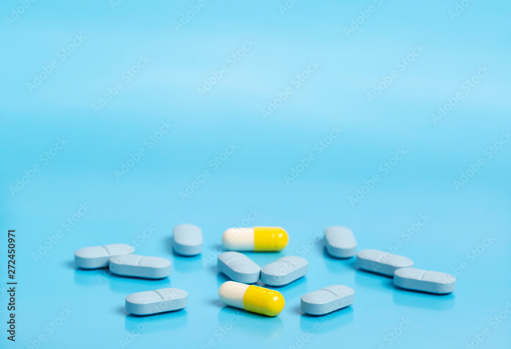 Blue and yellow medical pills on a blue background