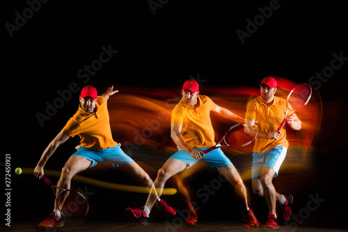 One caucasian man playing tennis isolated on black background in mixed light. Studio shot of fit young male player in motion or action during sport game. Concept of movement, sport, healthy lifestyle. © master1305