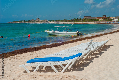 Fishing boat and deckchairs taken on the beach of Tulum, in the Mexican Yucatan peninsula