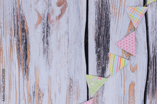 Birthday paper flags on rustic background. Decorative party flags on vintage wooden background with copy space.