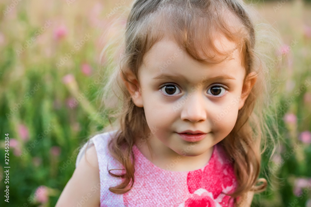 Cute thoughtful baby girl outdoors in green field. Child portrait Cute thoughtful baby girl outdoors in green field. Child portrait