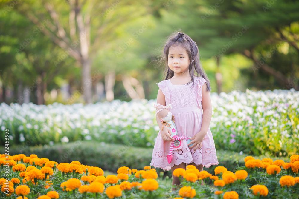 Cute little asian girl with a doll in the garden Cute little asian girl with a doll in the garden