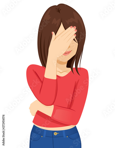 Young brunette woman covering her face with hand ashamed