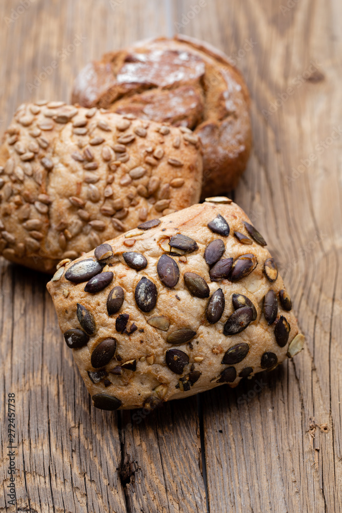Gold rustic crusty loaves of bread and buns on wooden background. Still life captured from above top view, flat lay. Gold rustic crusty loaves of bread and buns on wooden background. Still life captured from above top view, flat lay.