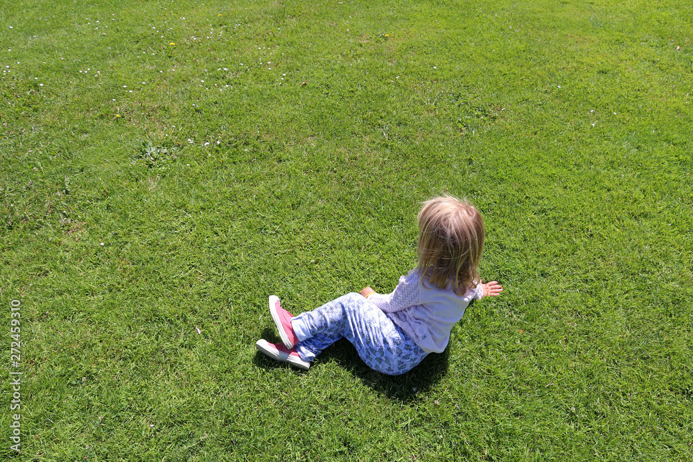 little blond girl lying on grass during summer holidays little blond girl lying on grass during summer holidays