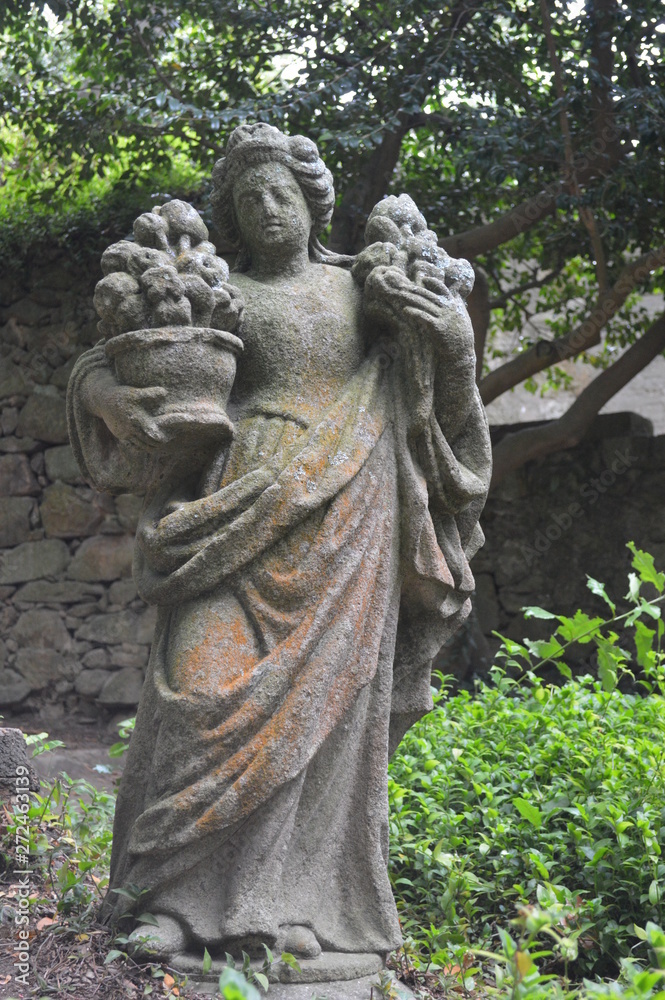 Escultura de un ángel en un bosque.