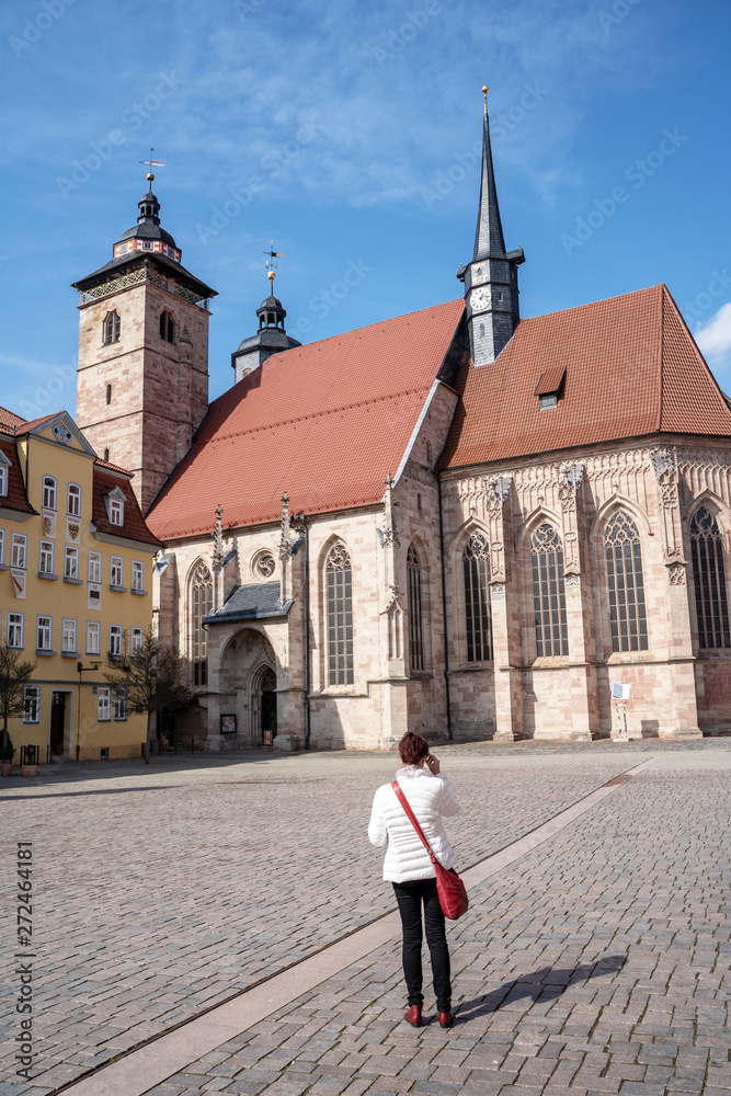 Obraz premium Junge Frau schaut auf die Stadtkirche in Schmalkaldn