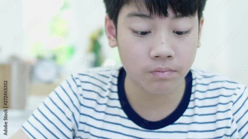 Preteen Asian boy eating chicken wings or nuggets fast food. close up happy boy enjoy his meal at home. Preteen Asian boy eating chicken wings or nuggets fast food. close up happy boy enjoy his meal at home.