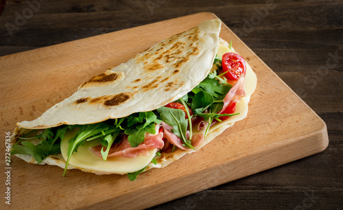 Romagna piadina filled on  chopping board photo