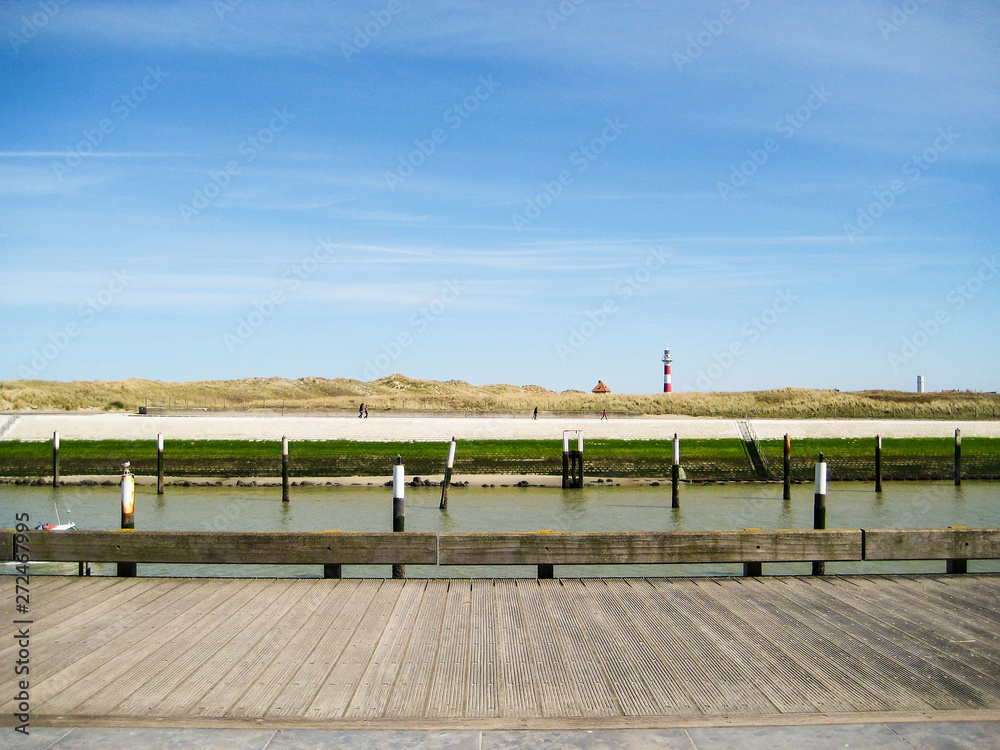 Promenade ensoleillée le long du chenal de Nieuport, phare à l'horizon