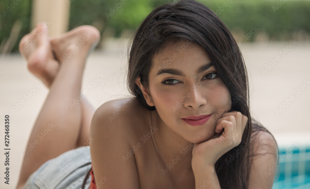 Asian beautiful women portrait lying beside the pool on a relaxing day Asian beautiful women portrait lying beside the pool on a relaxing day
