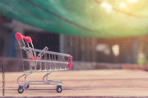 Shopping concept - Empty red shopping cart on brown wood table. online shopping consumers can shop from home and delivery service. with copy space