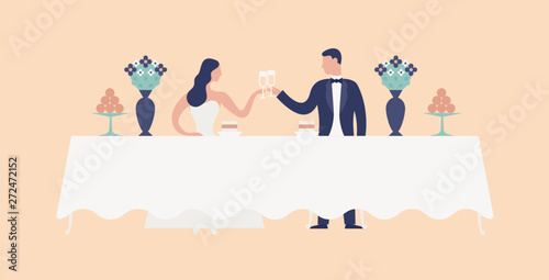 Bride and groom sitting at wedding feast table, clinking glasses and drinking champagne