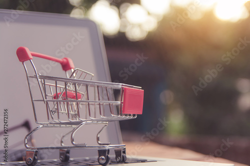 Shopping online concept - shopping cart or trolley on a laptop keyboard. Shopping service on The online web.