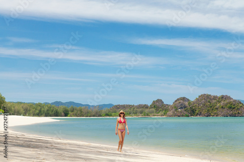 Young attractive woman walking on the sea beach