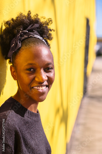 Young african woman with updo on yellow background