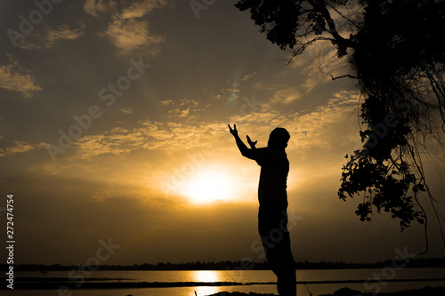 Silhouette Young asian muslim man praying on sunset,Ramadan festival concept