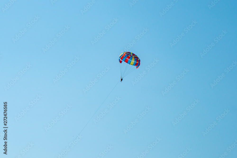 The operated parachute flies in high in the blue sky The operated parachute flies in high in the blue sky