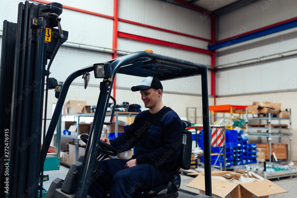 Man driving a forklift truck inside factory Man driving a forklift truck inside factory