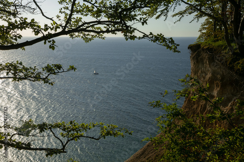 idyllic sea view with streep coast and sailboat photo