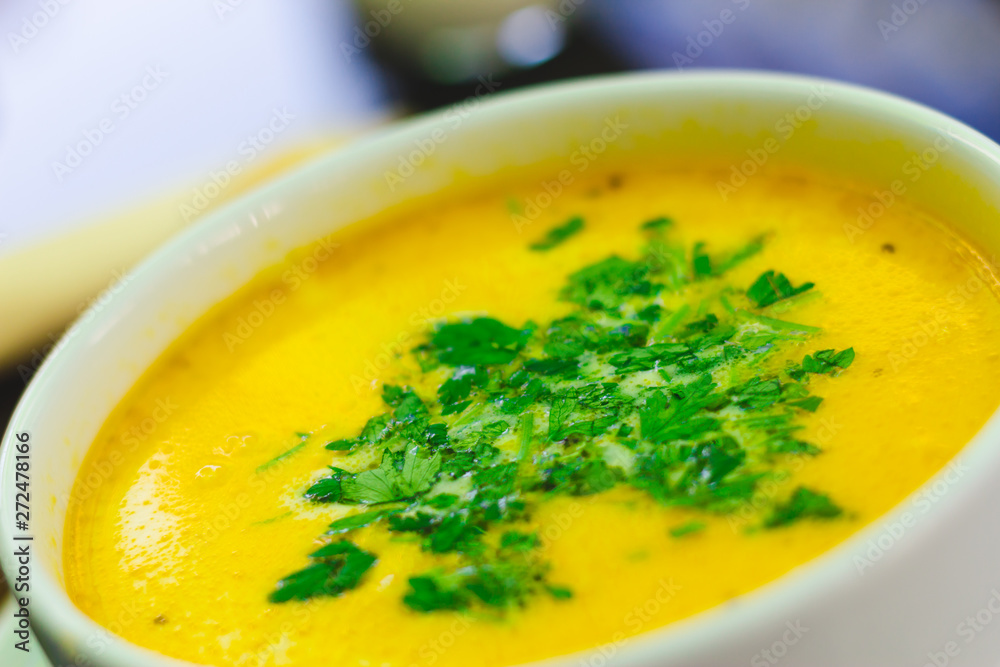 Delicious yellow chicken soup with green parsley on top in a white bowl at the restaurant – Creamy and healthy dish perfect for the main course Delicious yellow chicken soup with green parsley on top in a white bowl at the restaurant – Creamy and healthy dish perfect for the main course