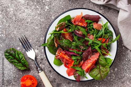 Healthy salad with prosciutto and tomato