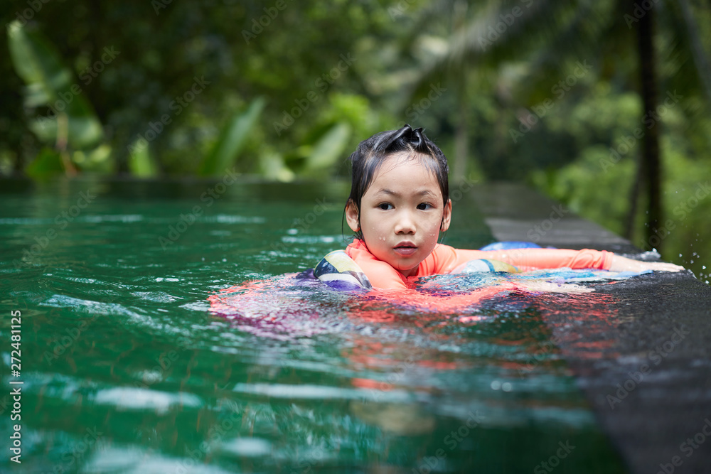 Cute Asian girl playing in an infinity pool with mandala scarves in the woods of nature Cute Asian girl playing in an infinity pool with mandala scarves in the woods of nature
