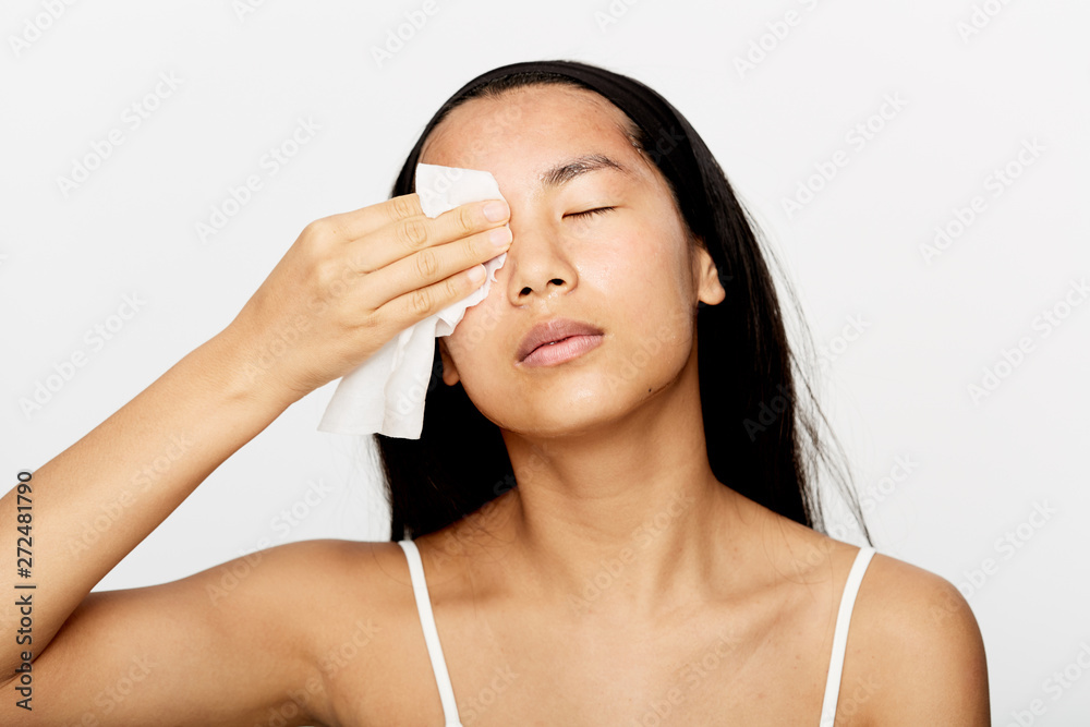 Beautiful young asian woman cleaning her face. Beautiful young asian woman cleaning her face.