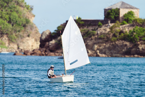 Boy in an optimist dinghy in English Harbour in Antigua