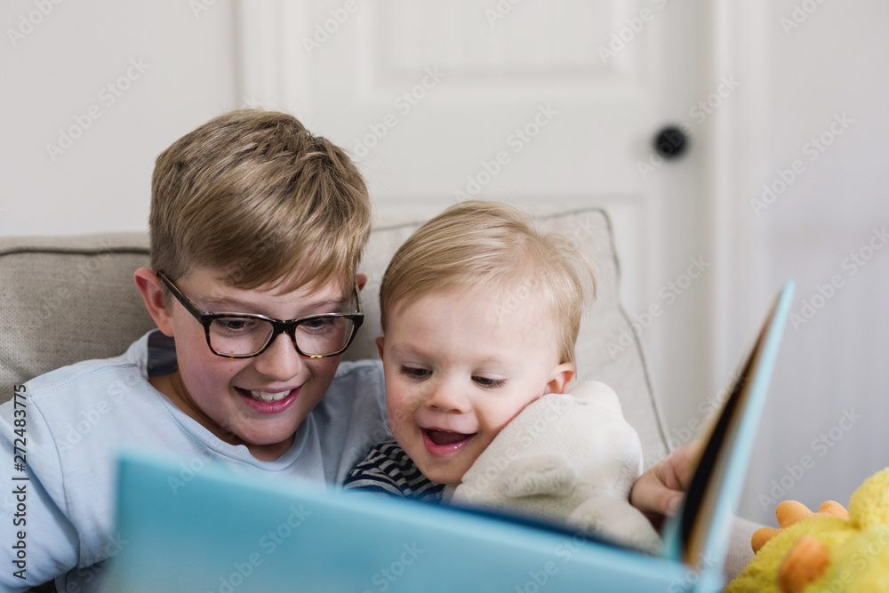 brothers enjoying a book together brothers enjoying a book together