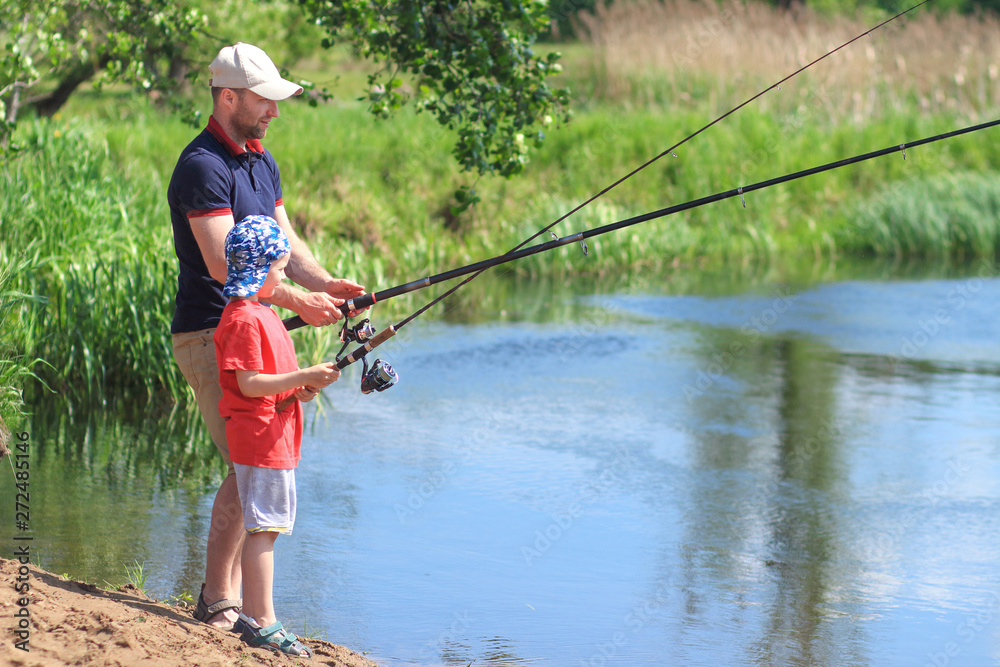 Family fishing. Father and son with fishing rods on lake side Family fishing. Father and son with fishing rods on lake side