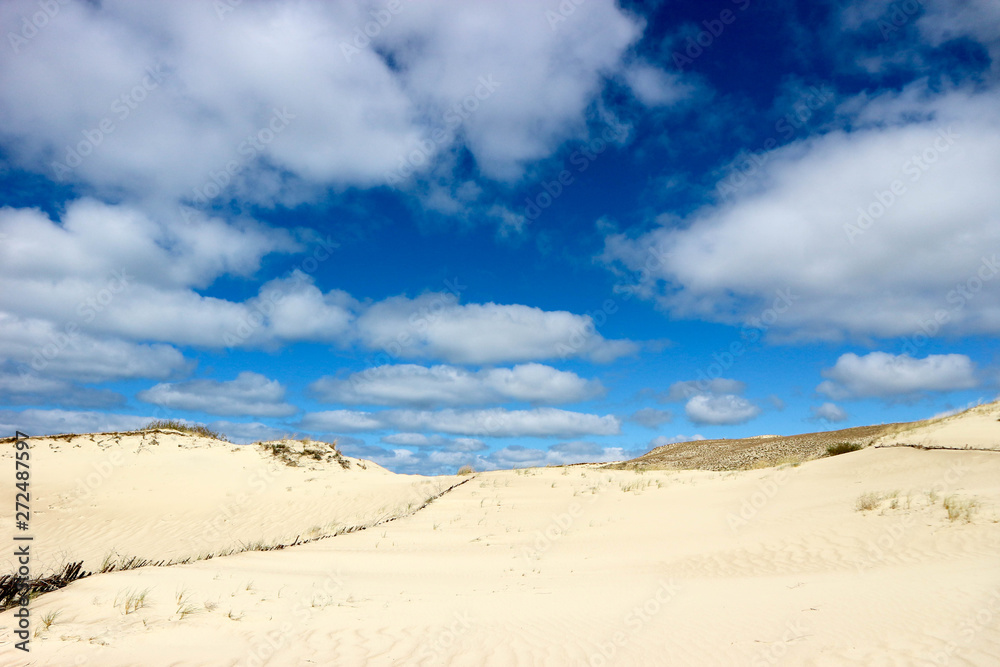 Fantastic beautiful view of sand dunes on Curonian Spit, Lithuania under the endless bright blue sky with clouds