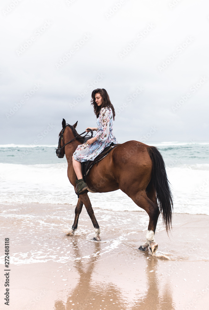 A girl riding a horse on the beach A girl riding a horse on the beach