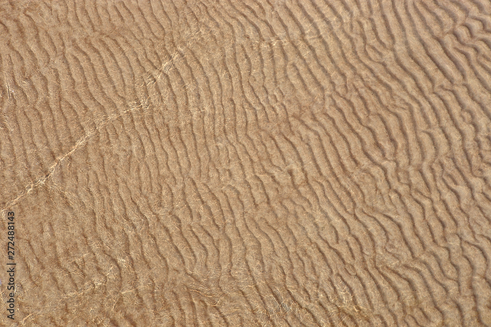 Sand texture created by sea waves on beach coast. Top view of sand pattern under soft waves. Sand texture of Baltic sea coast. Sand texture created by sea waves on beach coast. Top view of sand pattern under soft waves. Sand texture of Baltic sea coast.