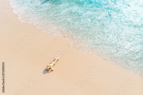 Young woman laying on sand beach