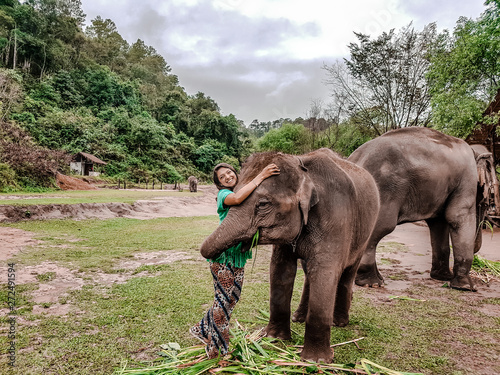Girl having fun with elephants at Patara Elephant Farm, Chiang Mai, Thailand