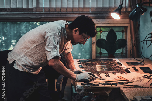 Cuadro en lienzo Expirienced diligent restorer is working on antique stained glass restoration at his own workshop