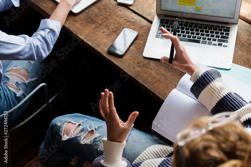 Woman on laptop, gesturing to employees