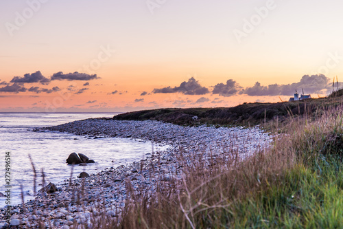 Sunset on a pebble beach by the Atlantic Ocean