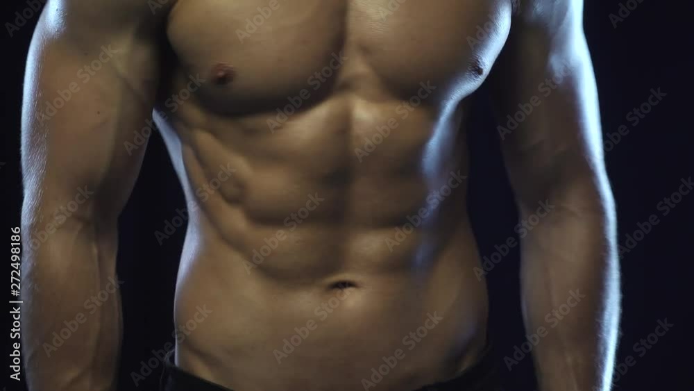 Young fit guy posing, showing abdominal muscles, seamless loop Young fit guy posing, showing abdominal muscles, seamless loop