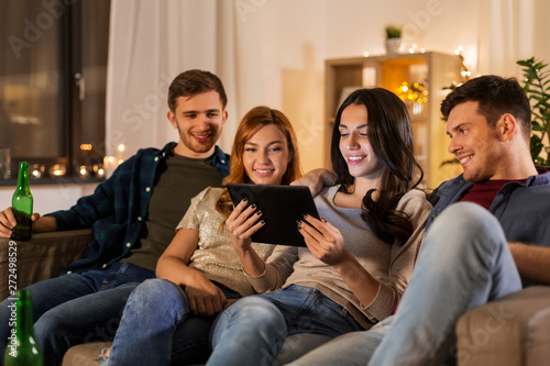 friendship  communication and people concept - group of happy friends with tablet computer drinking beer at home at night