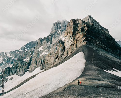 Two Unrecognizable Hikers Crossing Swiss Alpine Pass photo