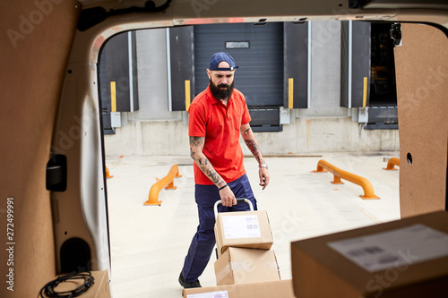 Worker loading freight into the car.