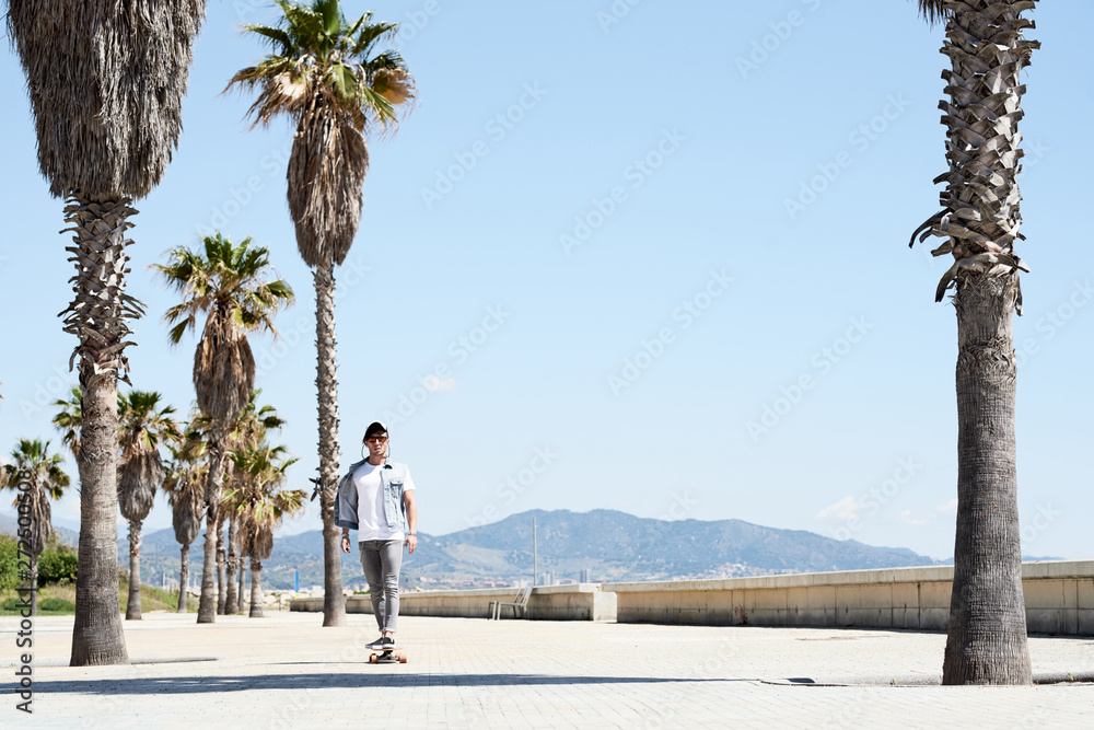 Man riding skateboard among palms Man riding skateboard among palms