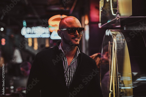 Portrait of happy smiling man at full of neon lights night club.